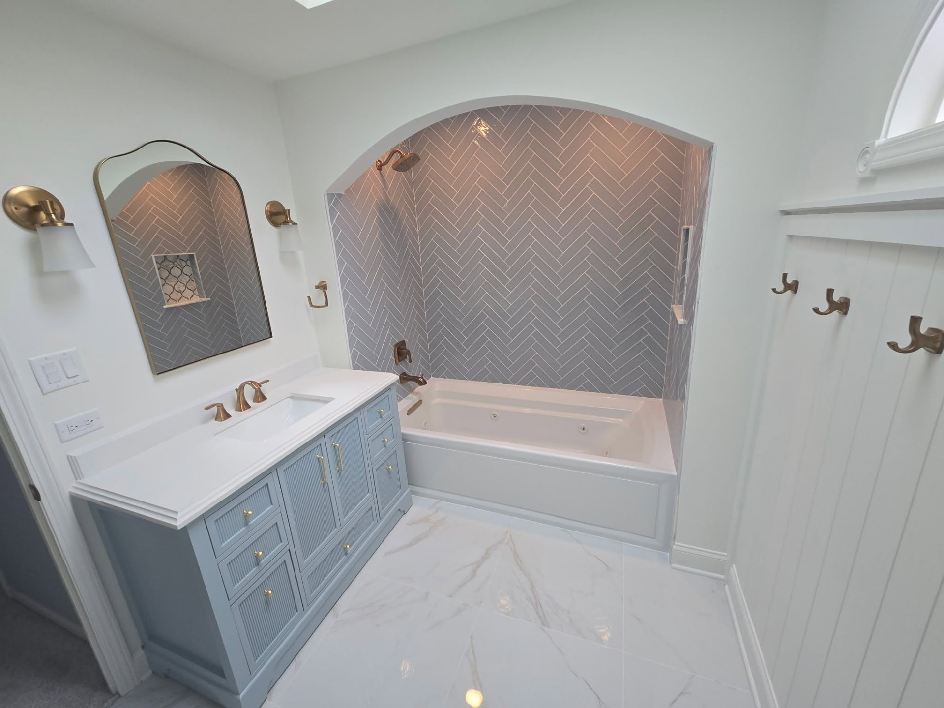 After: remodeled Lockport bathroom with blue vanity and arched herringbone tile